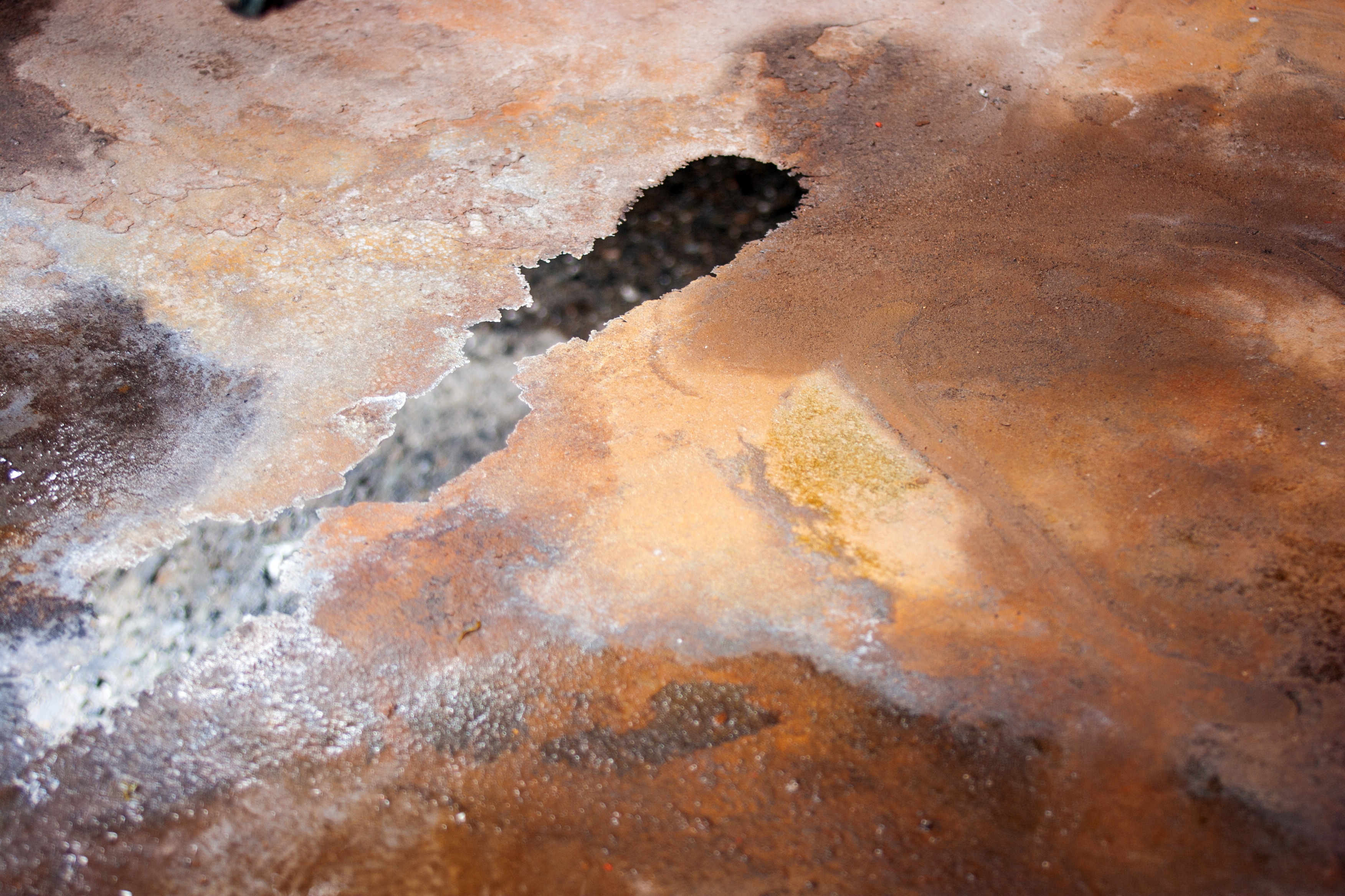 A steel surface which appears to be corrosive and covered in clear oil and grease