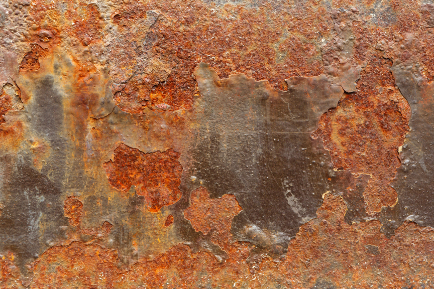 An image of dark brown spots of rust after moisture found cracks in the mill scale to alter the steel substrate.