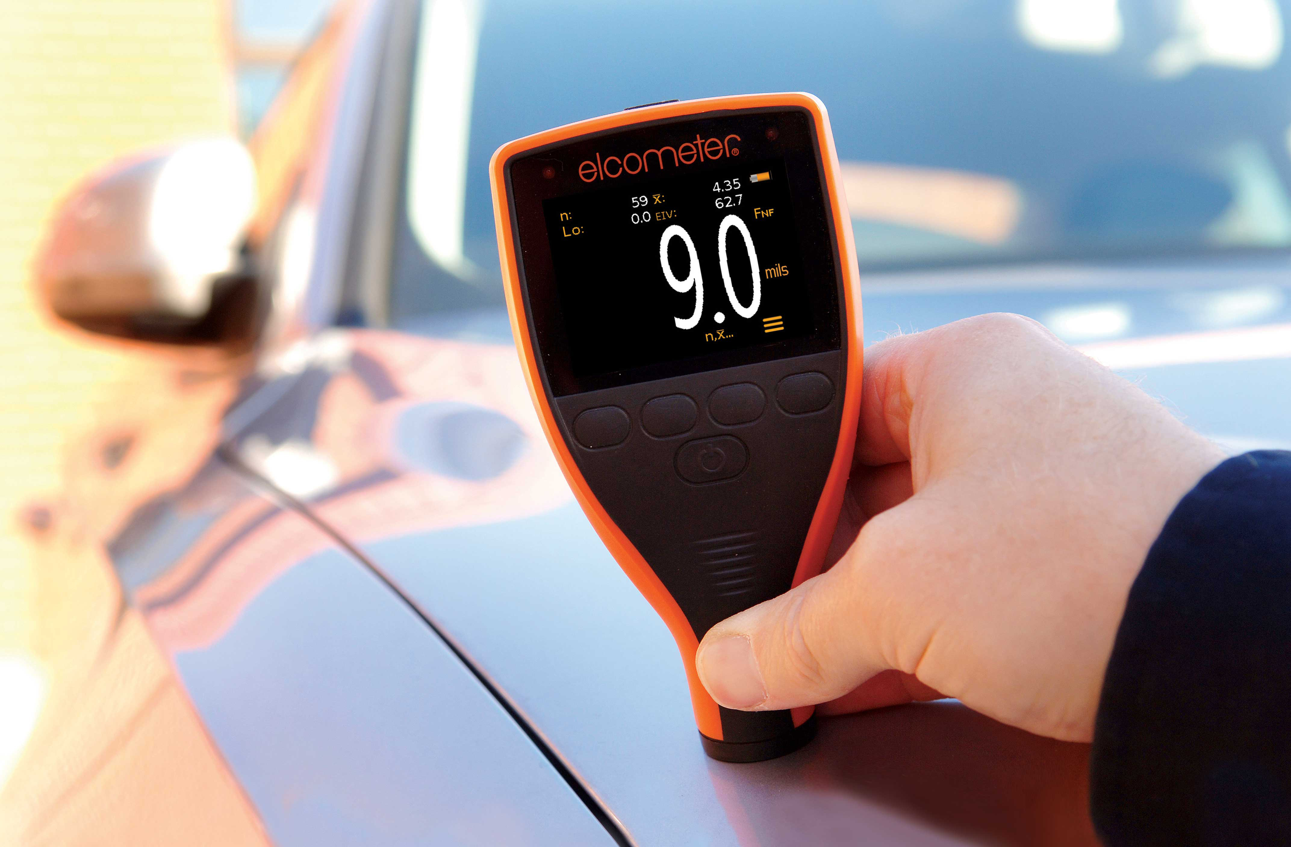 Elcometer 311 Automotive Paint Meter A Coating Inspector holding the Elcometer 311 Automotive Paint Meter on top of a vehicle to measure the paint thickness.