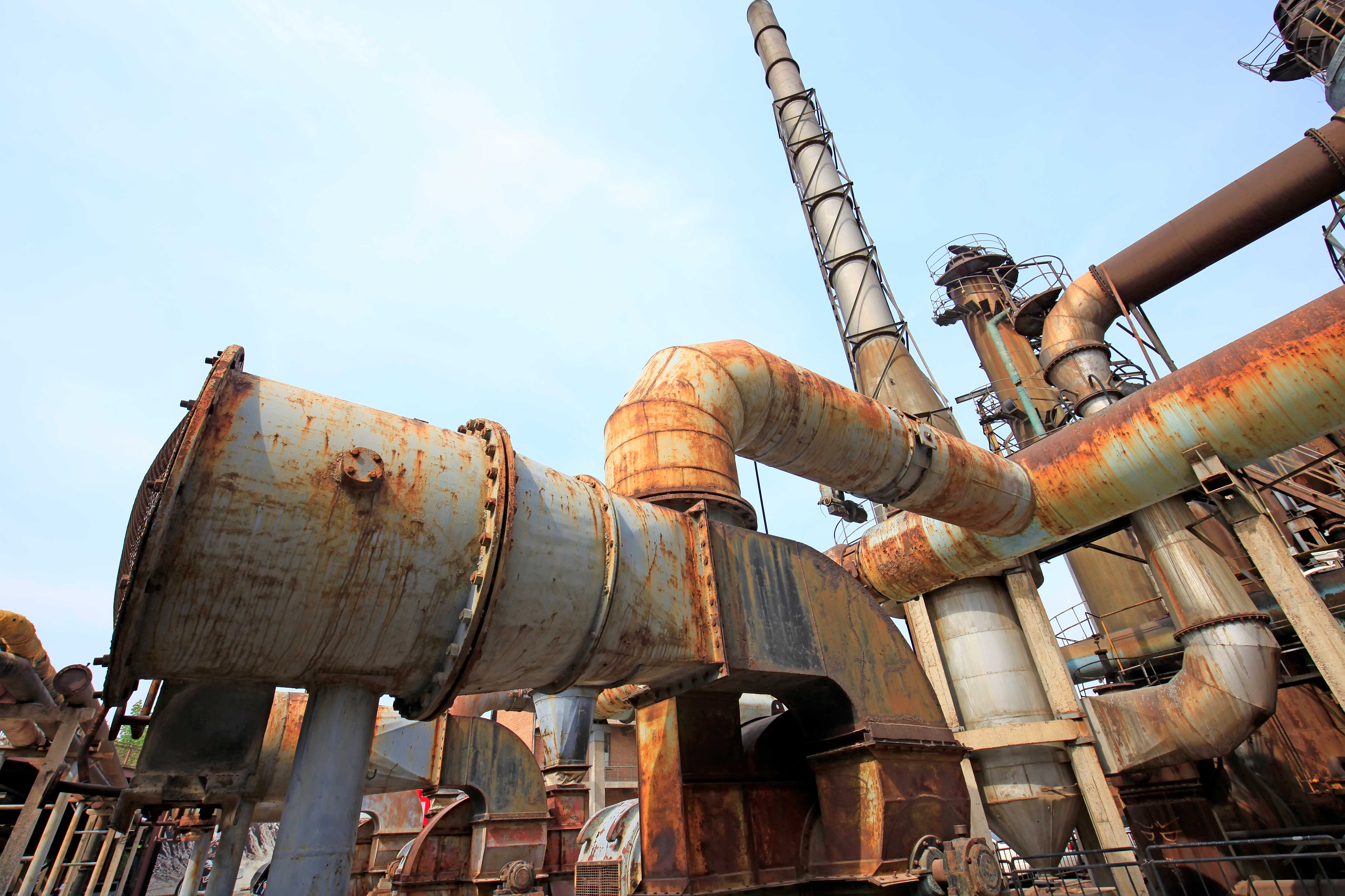 Large, metal oil welds covered in dark orange corrosion.